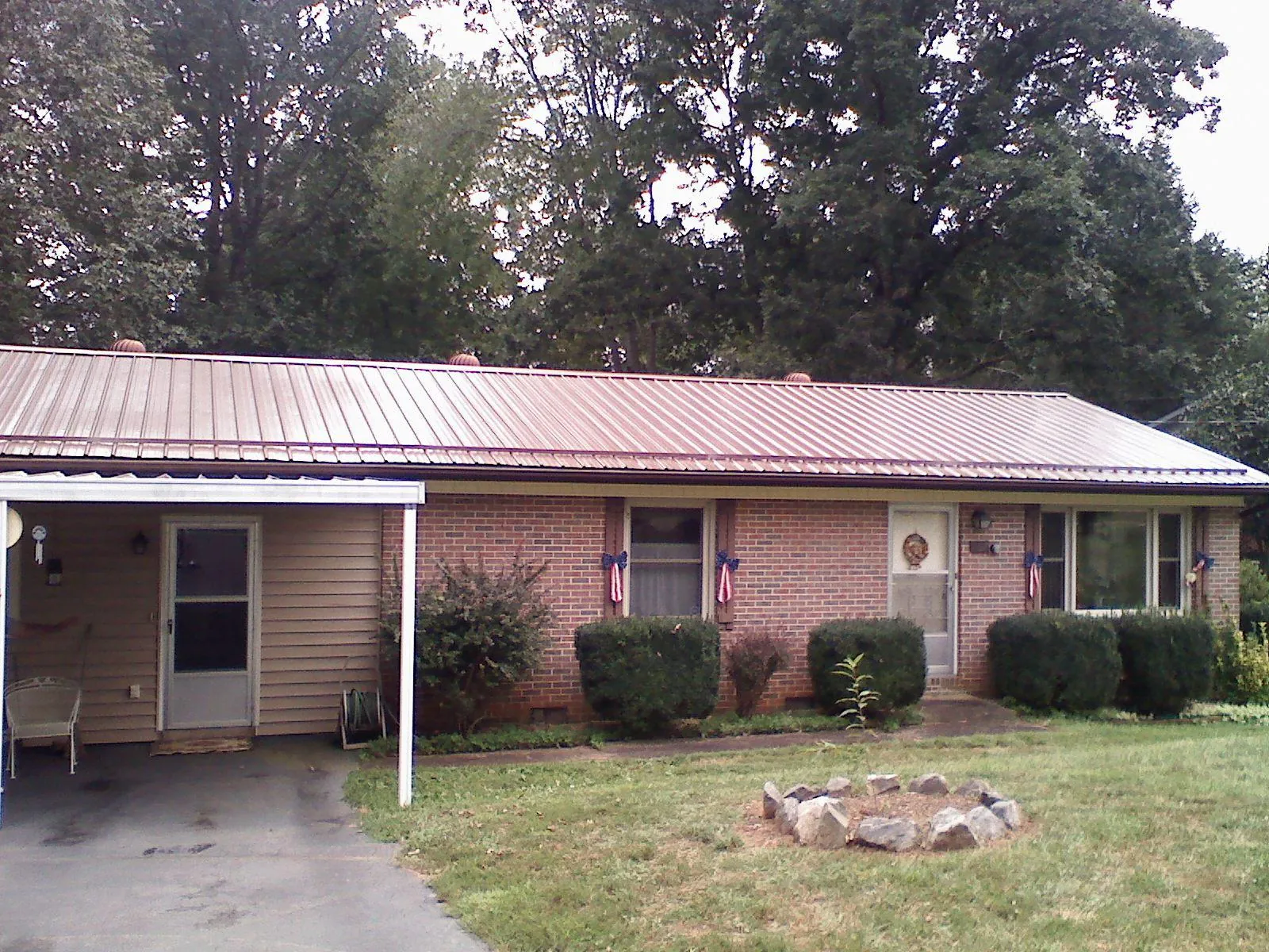 Bronze metal roof and carport on a brick ranch home — Roof Repair work by our crew in Kingston